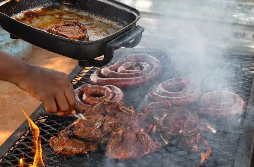 Traditionell sydafrikansk braai med grillat kött över vedeldad grill